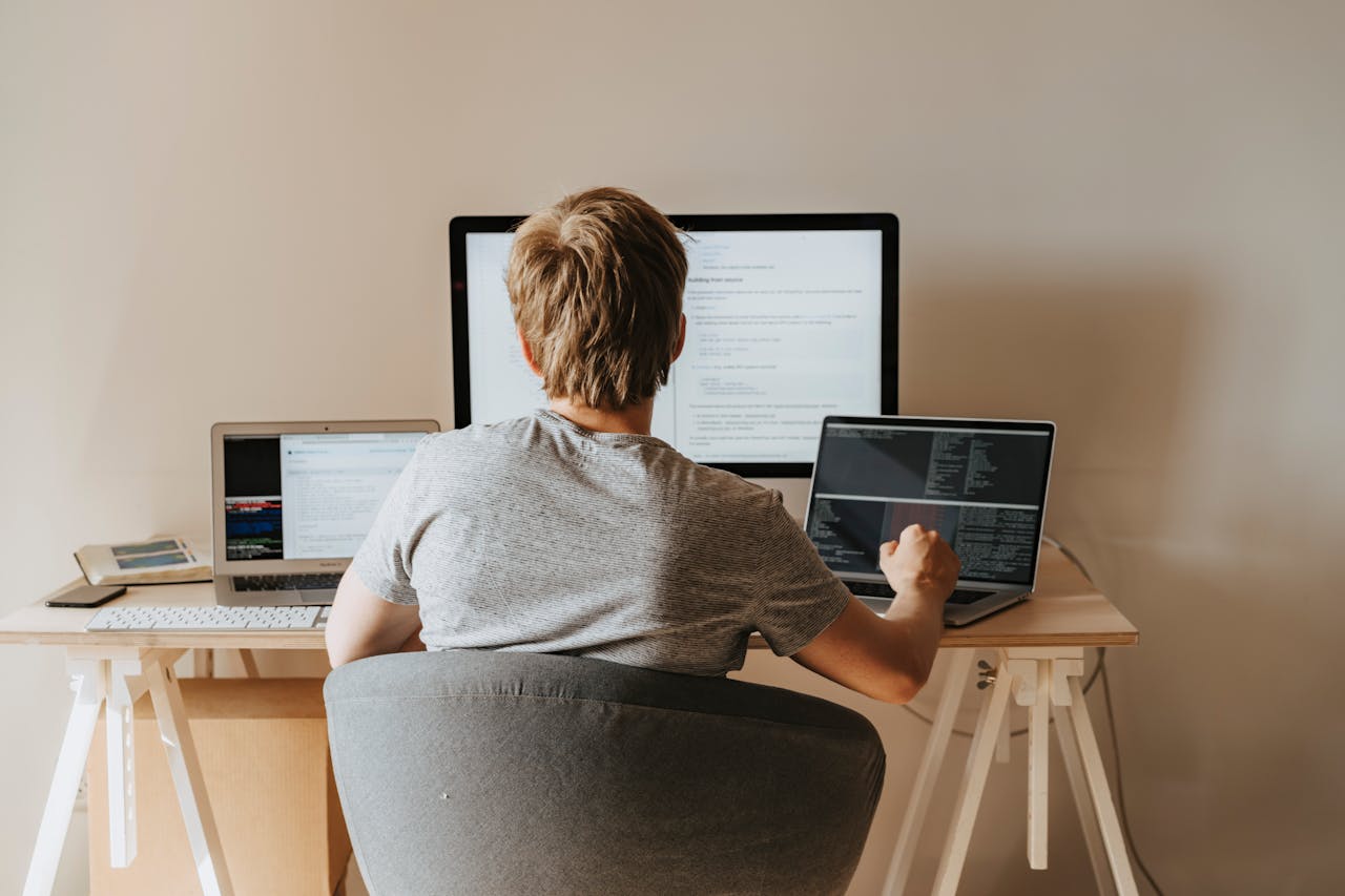 A person working on multiple laptops.